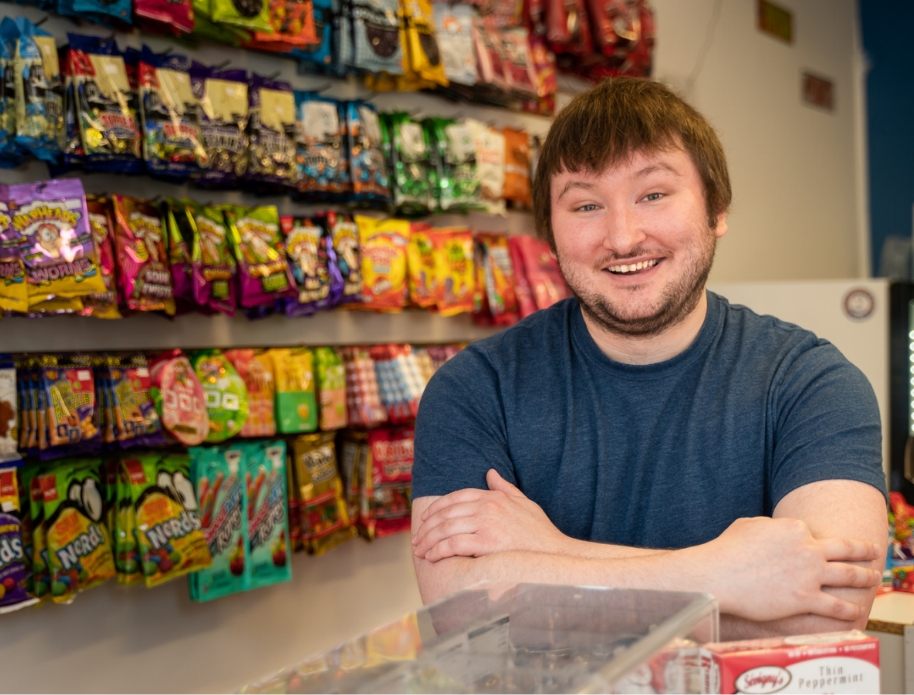 Male smiling and posing in his candy store