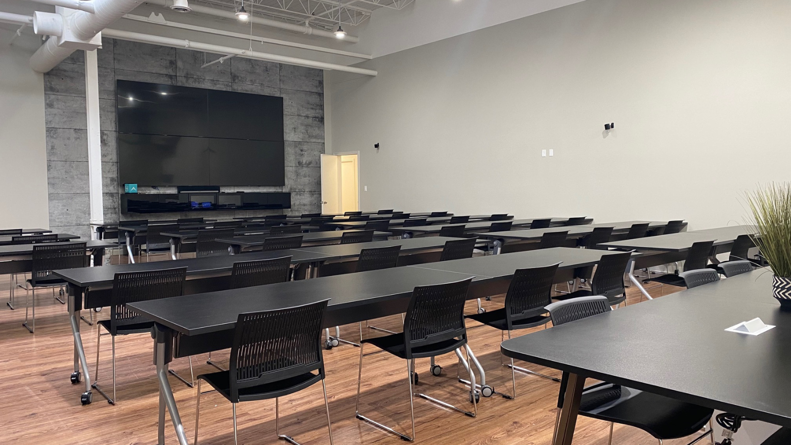 Innovation centre training room with tables, chairs, and tv