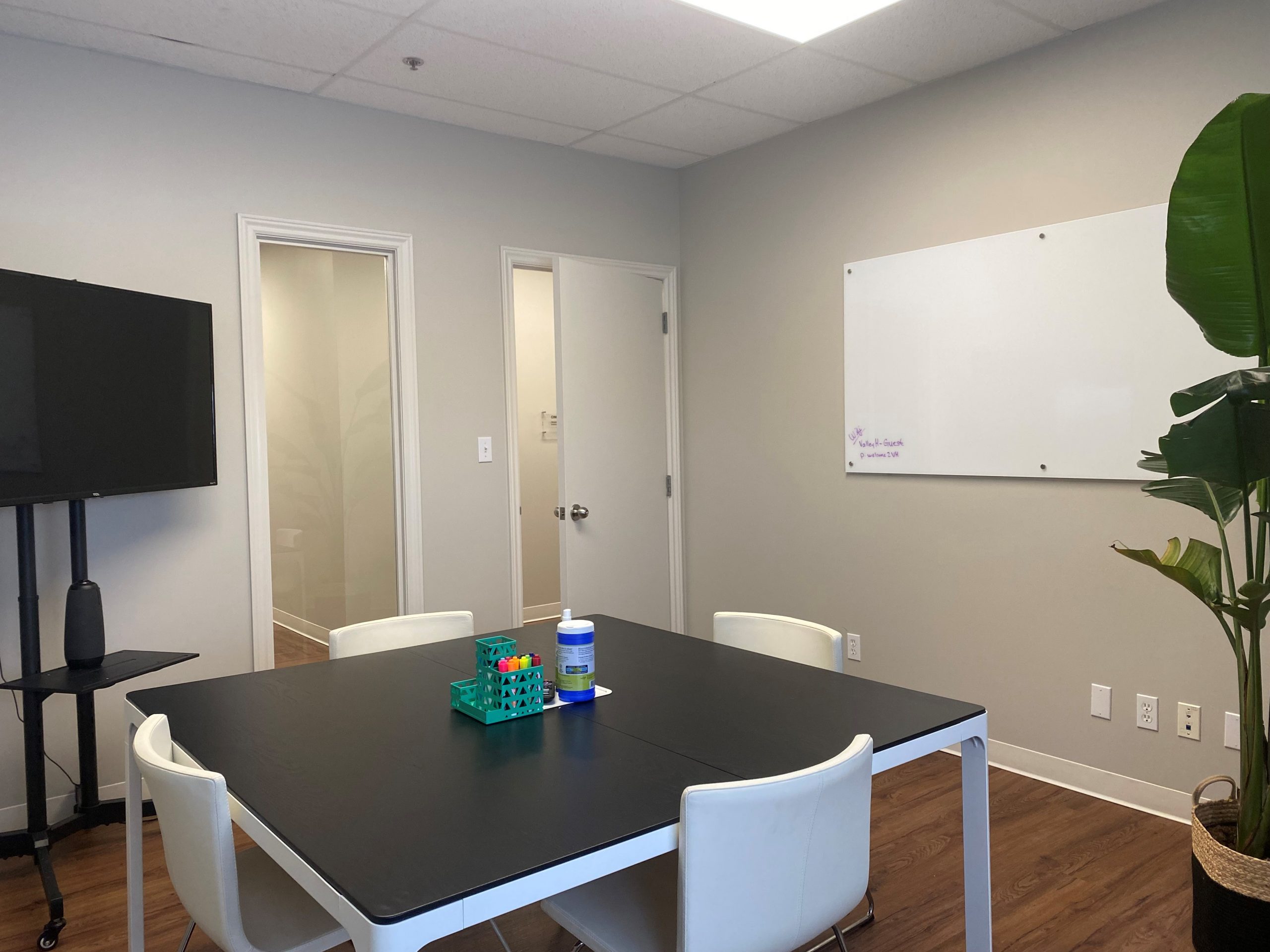 Think tank room with table, chairs, TV, and white board